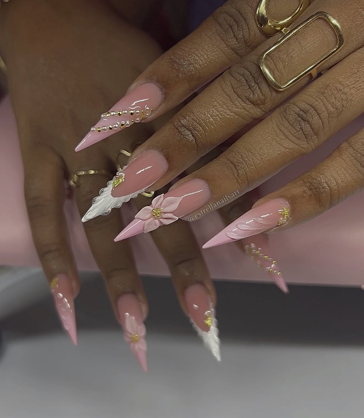 Ongles longs rose vif, détails blancs et dorés, motif plume